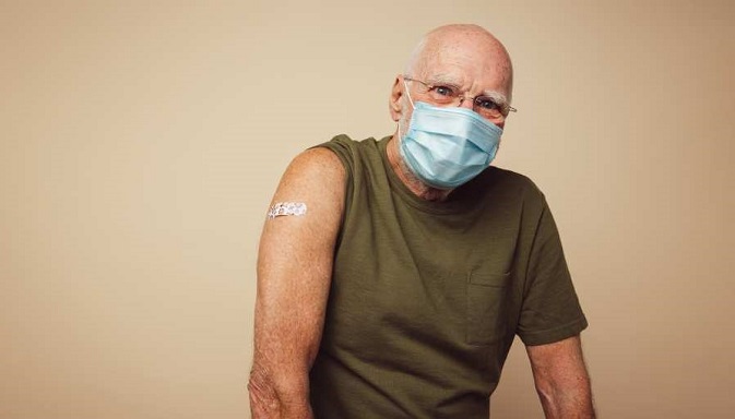 Photo of smiling man with band aid on arm