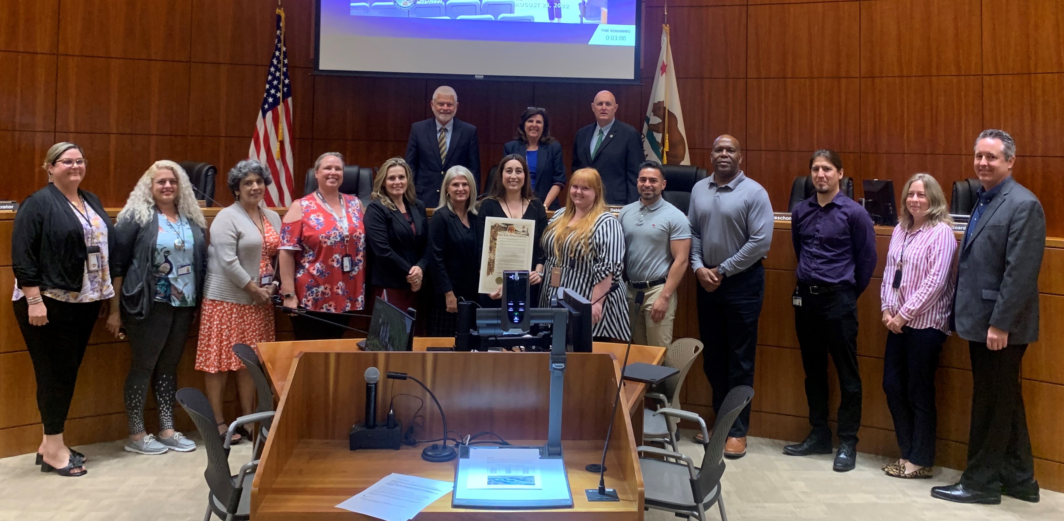 Child support staff are standing in front of the Board of Supervisor members, holding the resolution and smiling. Click to view article, Board of Supervisors proclaim August as “Child Awareness Month” 