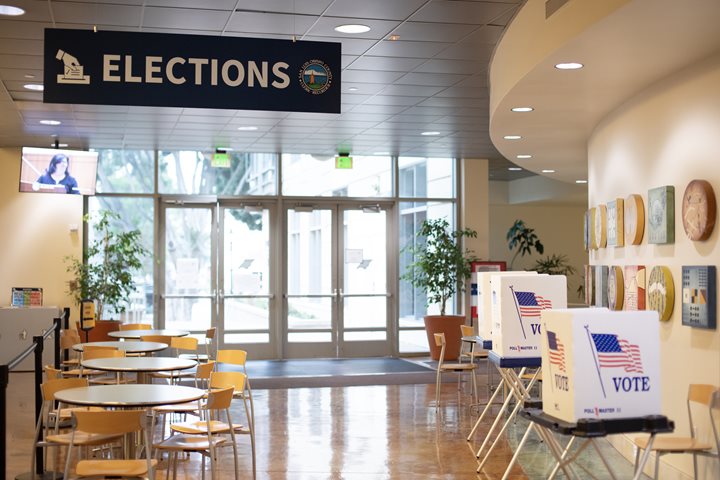 Photo of the Government Center lobby, including voting booths and a hanging Elections sign