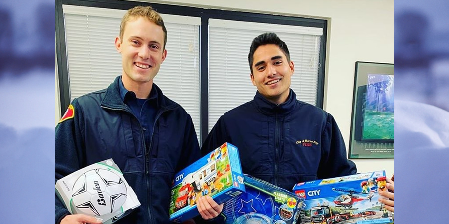 Two Firefighters holding toy donations