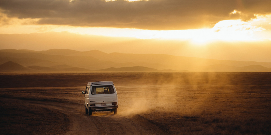 Van travels on dusty road