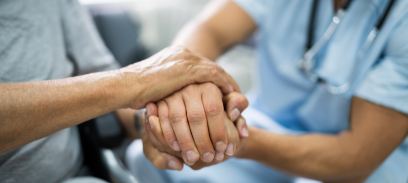 A doctor showing a patient support by holding their hands. Click to view article, Open Enrollment Underway for Covered California