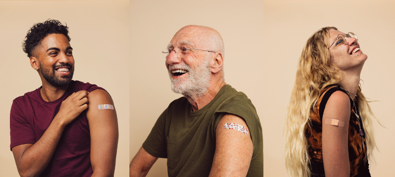 Photo of a young man, senior man, and young woman smiling after having received their vaccines.