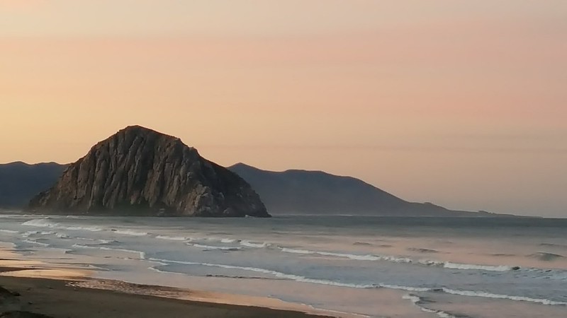 Morro Rock with small waves in the foreground at sunset