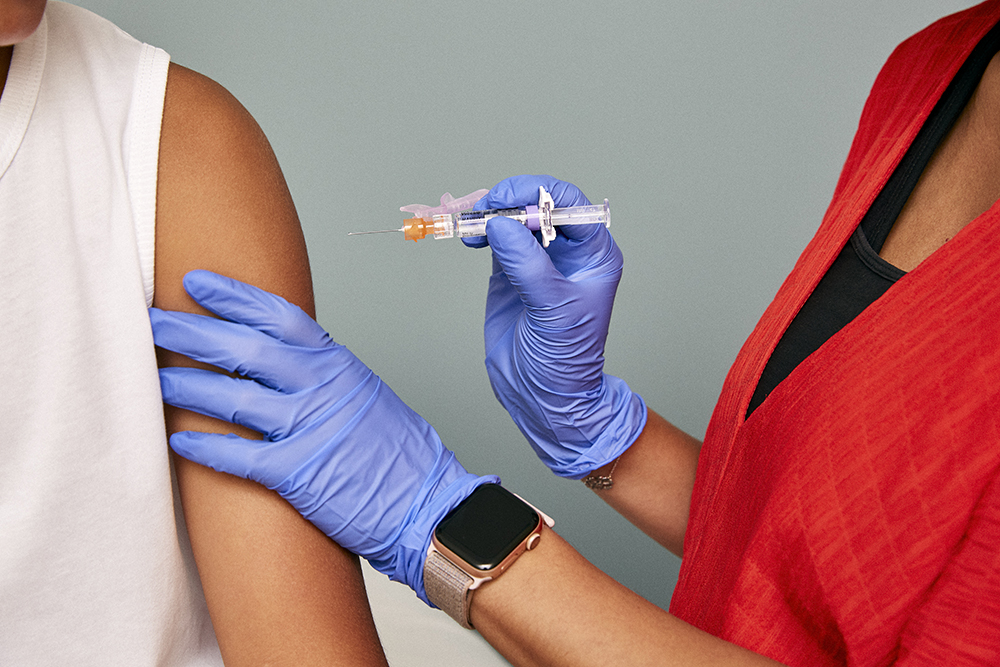 Person receiving vaccination from healthcare provider