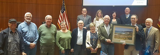 Airlin and the North Coast Advisory Council posing in front of the Board of Supervisors dais  Click to view article, Long-time County Planner Recognized for Service