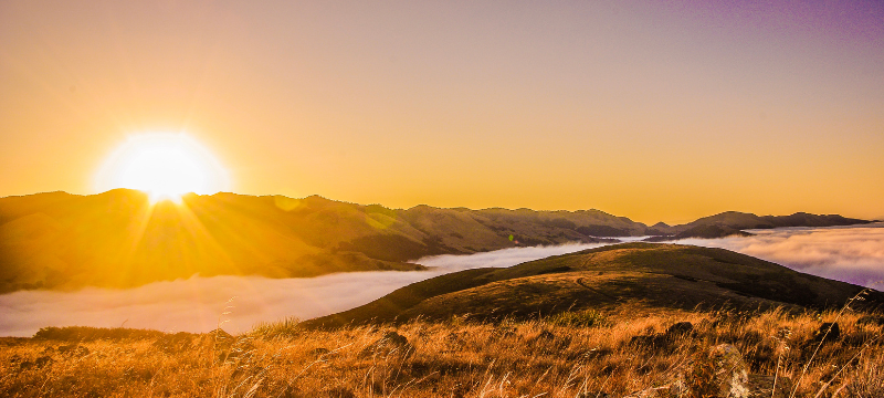 Sunset over hills with fog in a valley