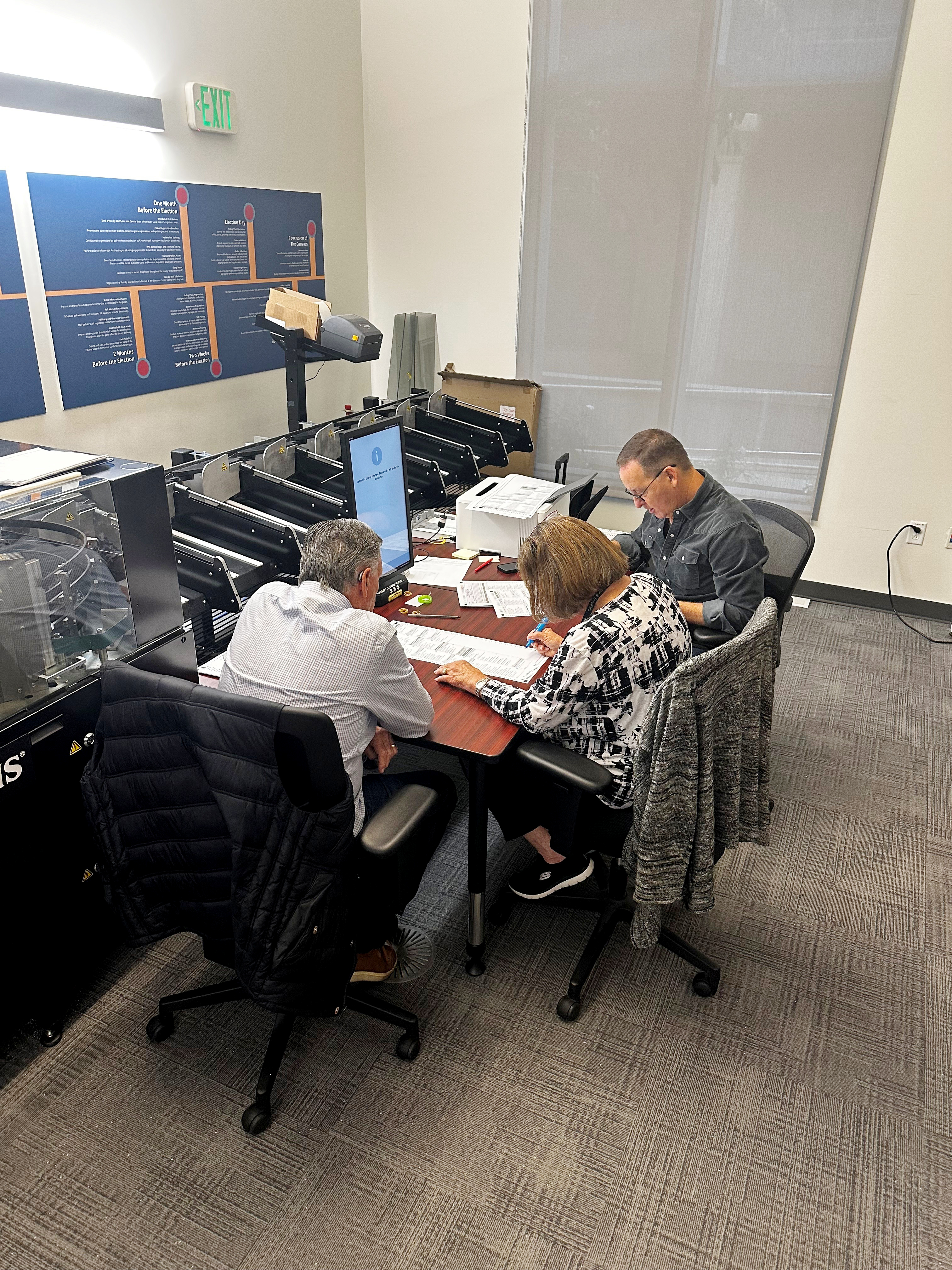 Three people at a table with ballots