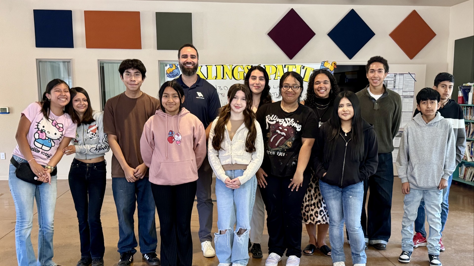 Group of teens and three public health professional smile as a group, the first year of the Public Health Scholars.
