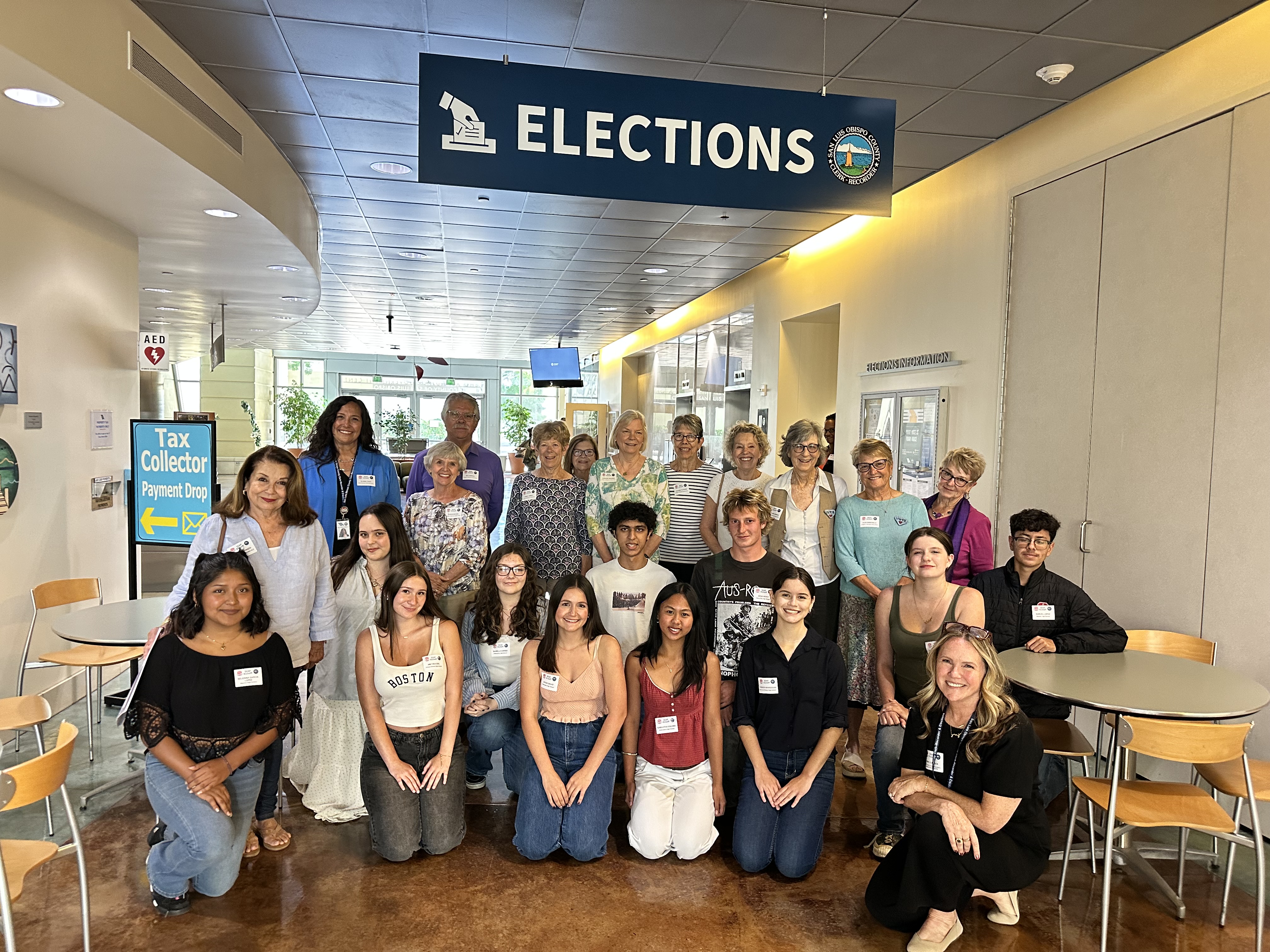 A group of students and adults under an "Elections" sign