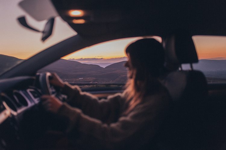 Teen driving car at sunset. 