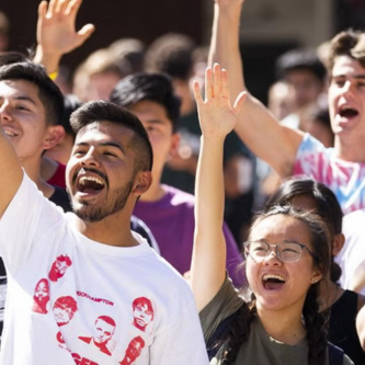 Crowd of Cal Poly students cheering at an outdoor event.