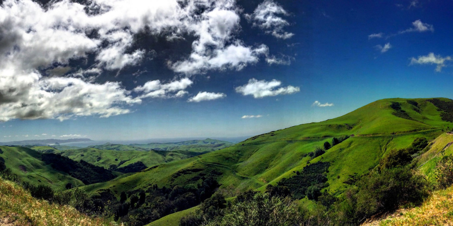 View of green hills and blue sky.