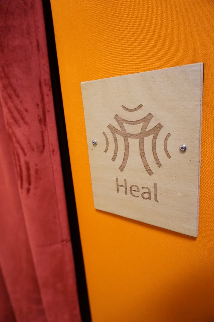 The Heal Pod, a rectangular sound booth with bench for meditation. 