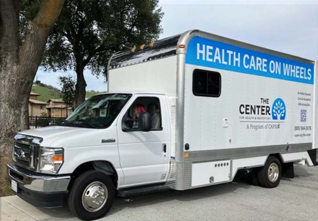 White van serving as mobile health unit with The Center logo in blue.