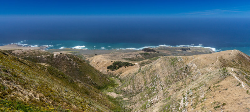 Coast with central California water next too large, steep, rolling hills.