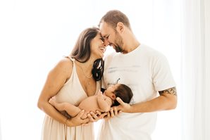 Photo of smiling parents holding baby