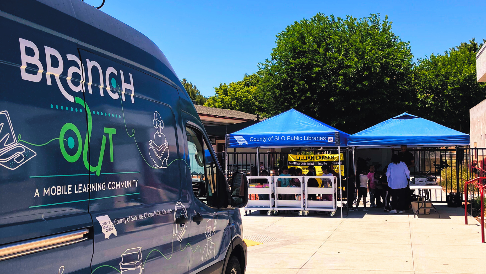 Image showing the SLO Library outreach van parked in front of an outdoor event booth